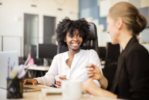 Smiling female business partners discuss ways to improve business operations in a bright office
