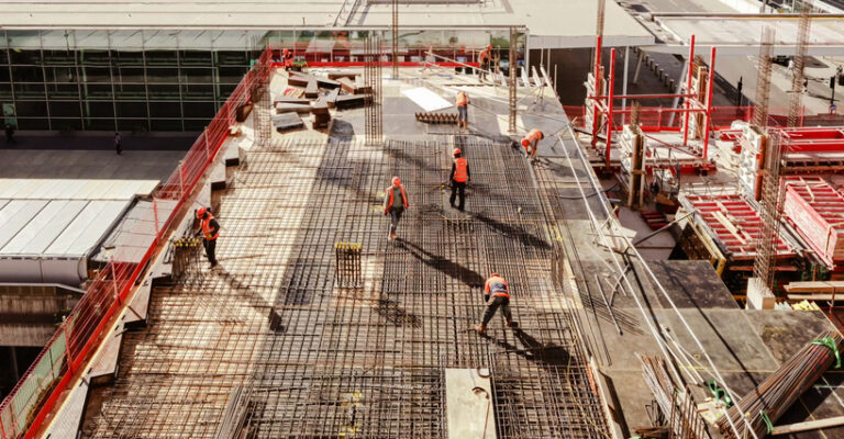 Workers on a building construction site from a high angle. Private equity in construction.
